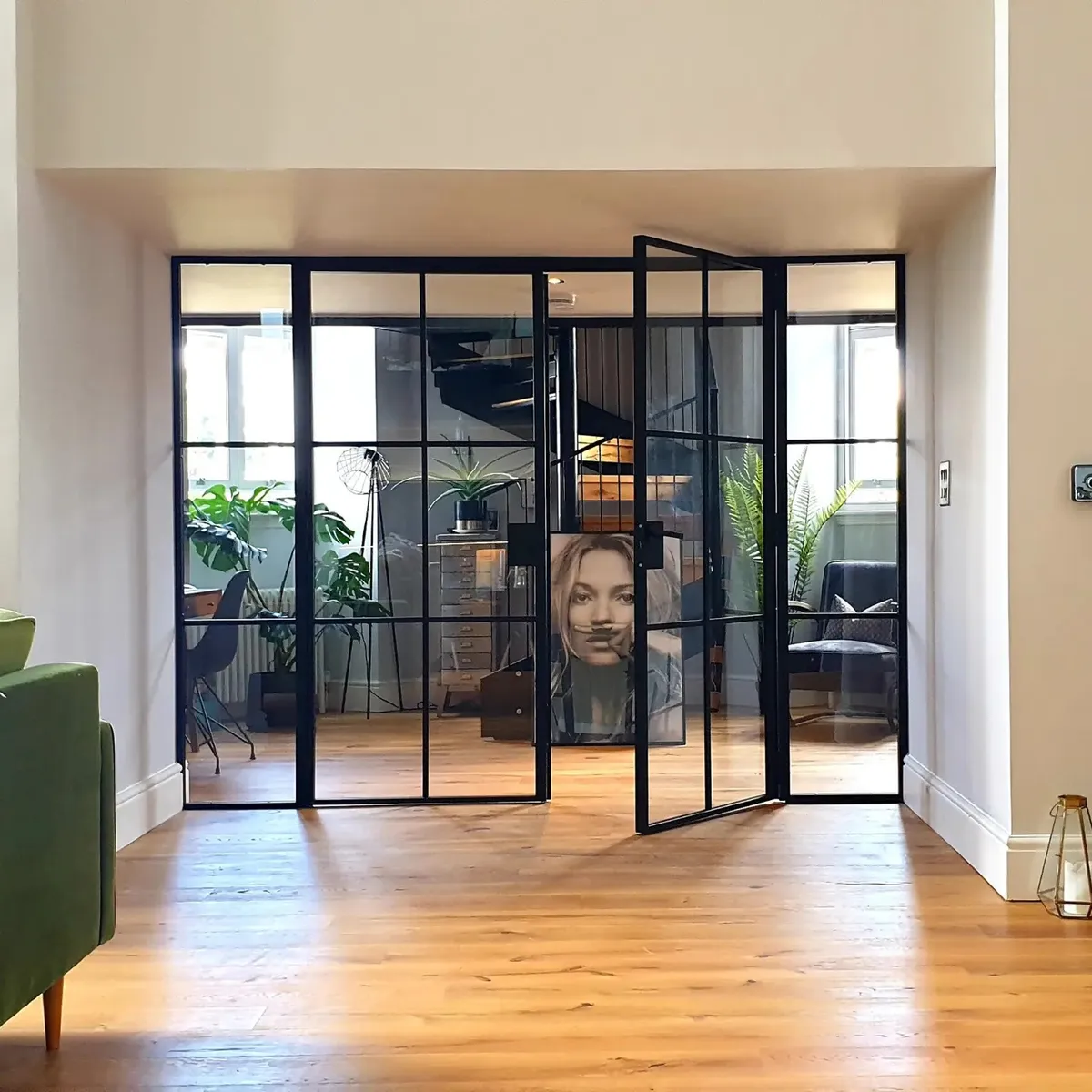 Glazed aluminium screen opening onto a warm courtyard