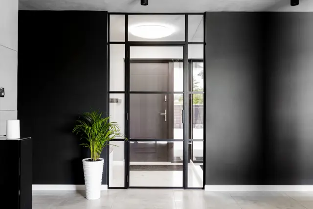 Glazed aluminium partition against a black wall