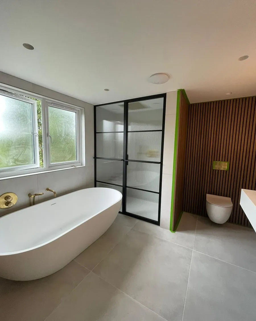 Fixed glazed aluminium partition beside a bathtub